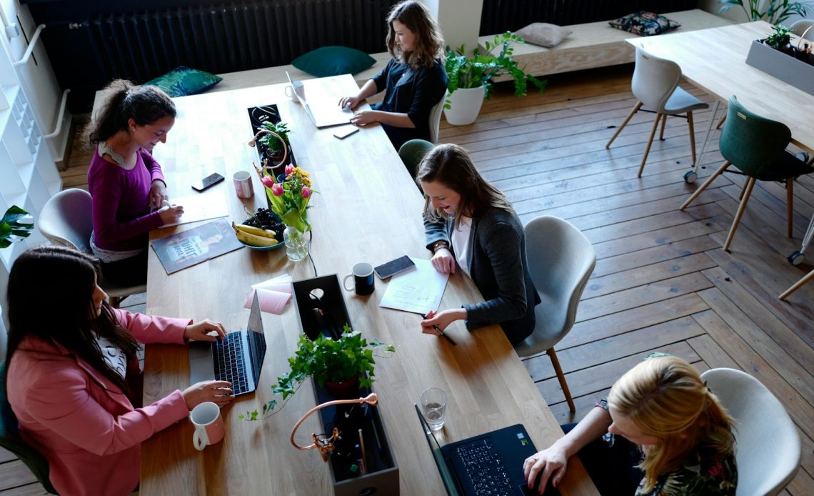 a group of people sitting around a wooden table