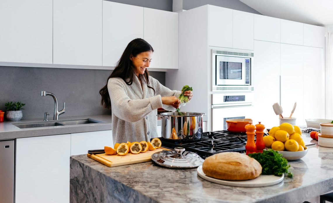 woman smiling while cooking