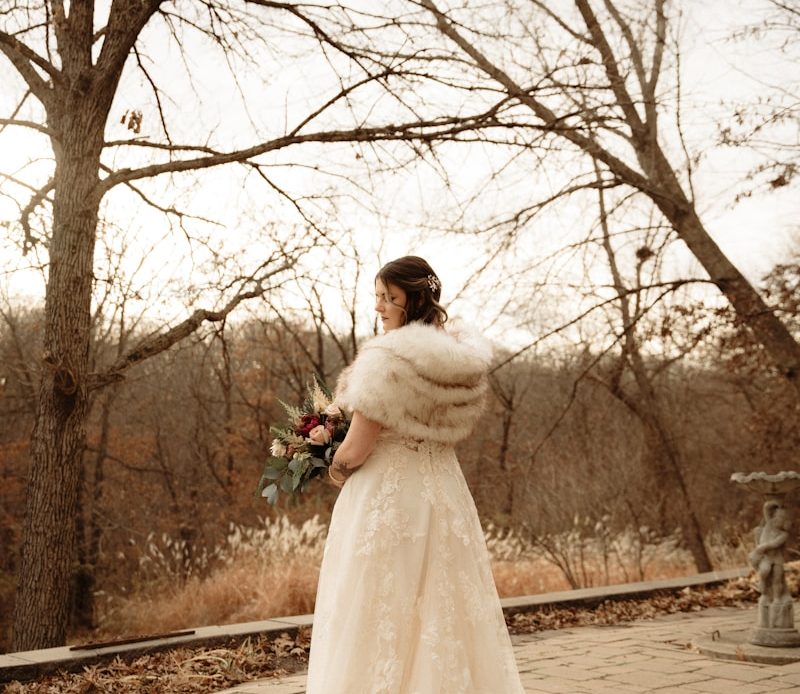 a woman in a wedding dress standing in front of a tree