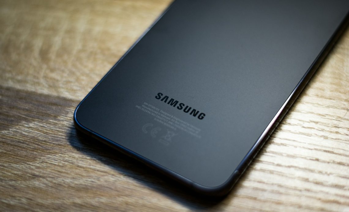a close up of a samsung phone on a wooden table