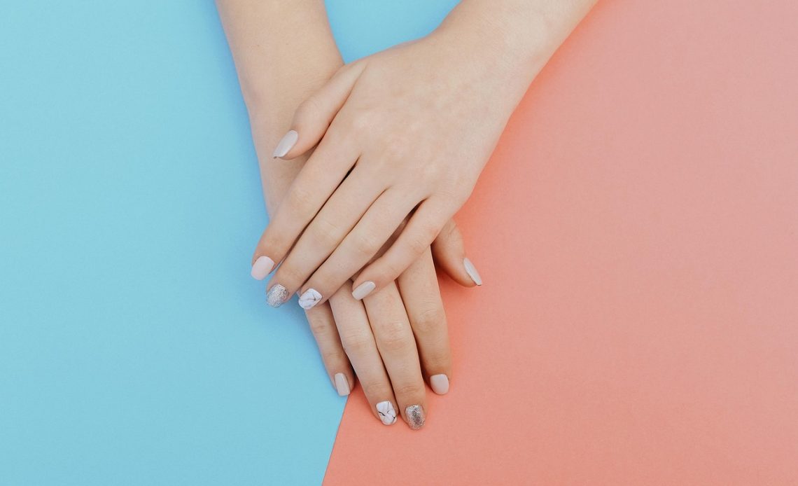Vrouw die gel nagellak aanbrengt op haar nagels thuis