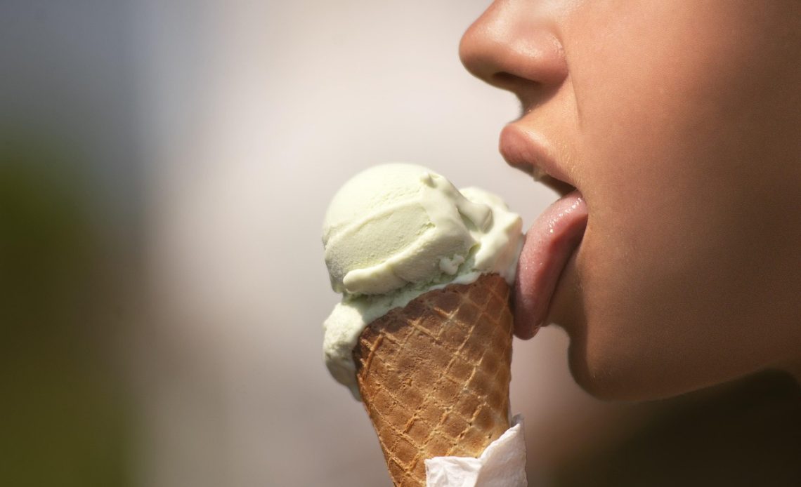 Vrouw die gezichtscrème aanbrengt naast een zwembad ter herstel van de huidbarrière na het zwemmen