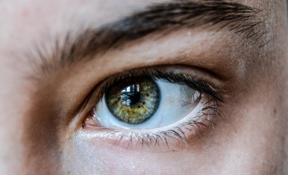 Vrouw die wimperserum aanbrengt met precisie-applicator bij de oogrand