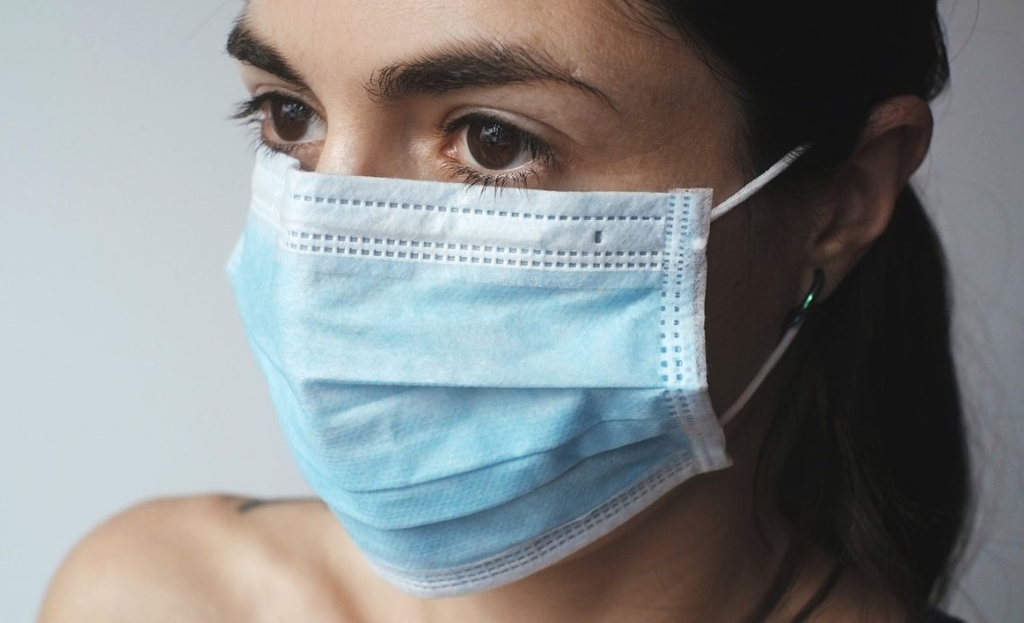Vrouw die voorzichtig een kalmerend gezichtsmasker aanbrengt op haar huid