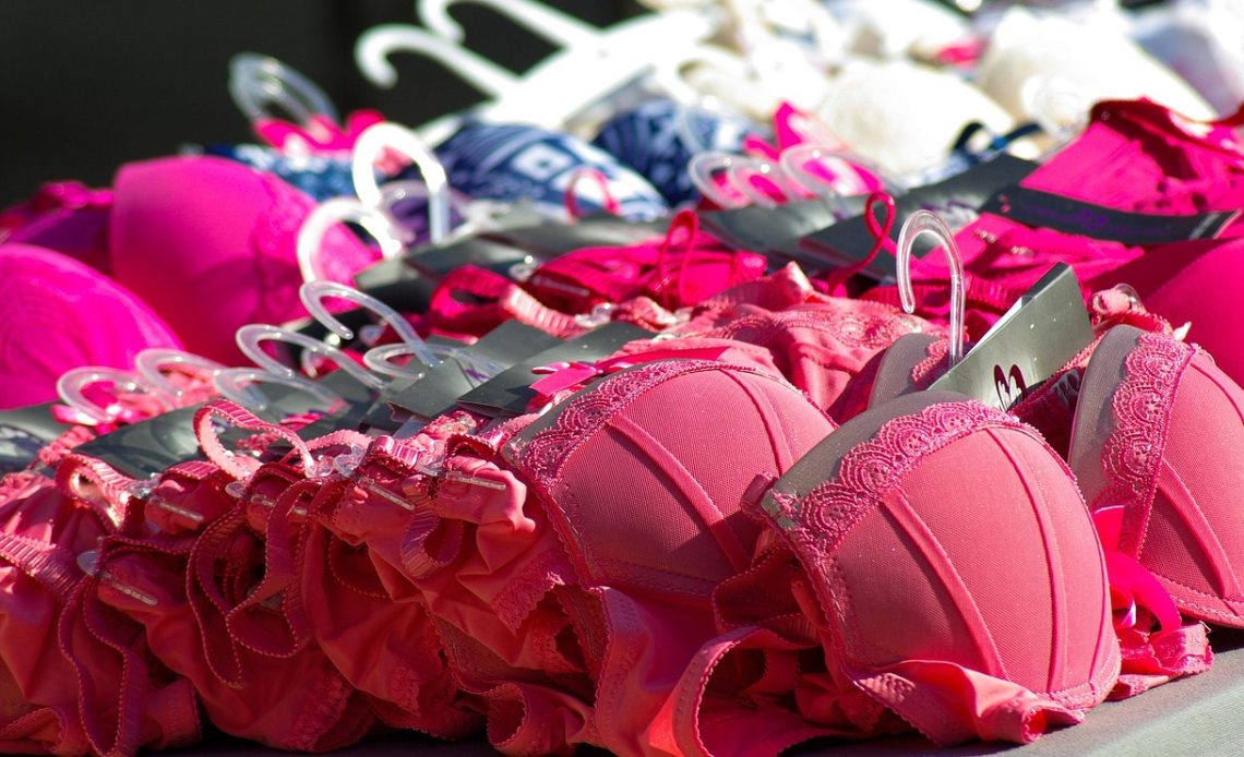 Vrouw die een push-up beha past in een lingeriewinkel en de pasvorm controleert