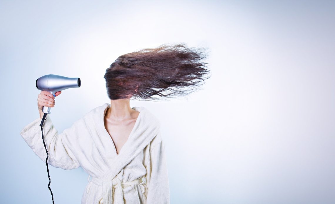 Vrouw die haar haar borstelt en haaruitval bekijkt