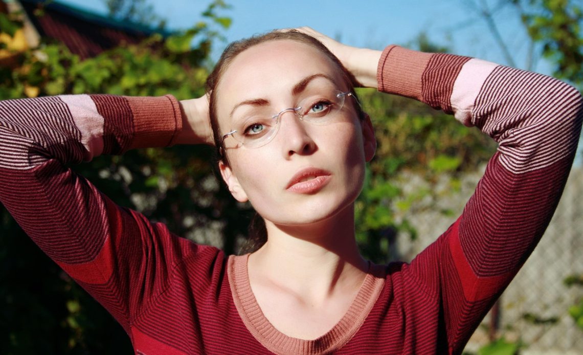 Vrouw die een strakke turtleneck draagt en zichzelf bekijkt in een passpiegel