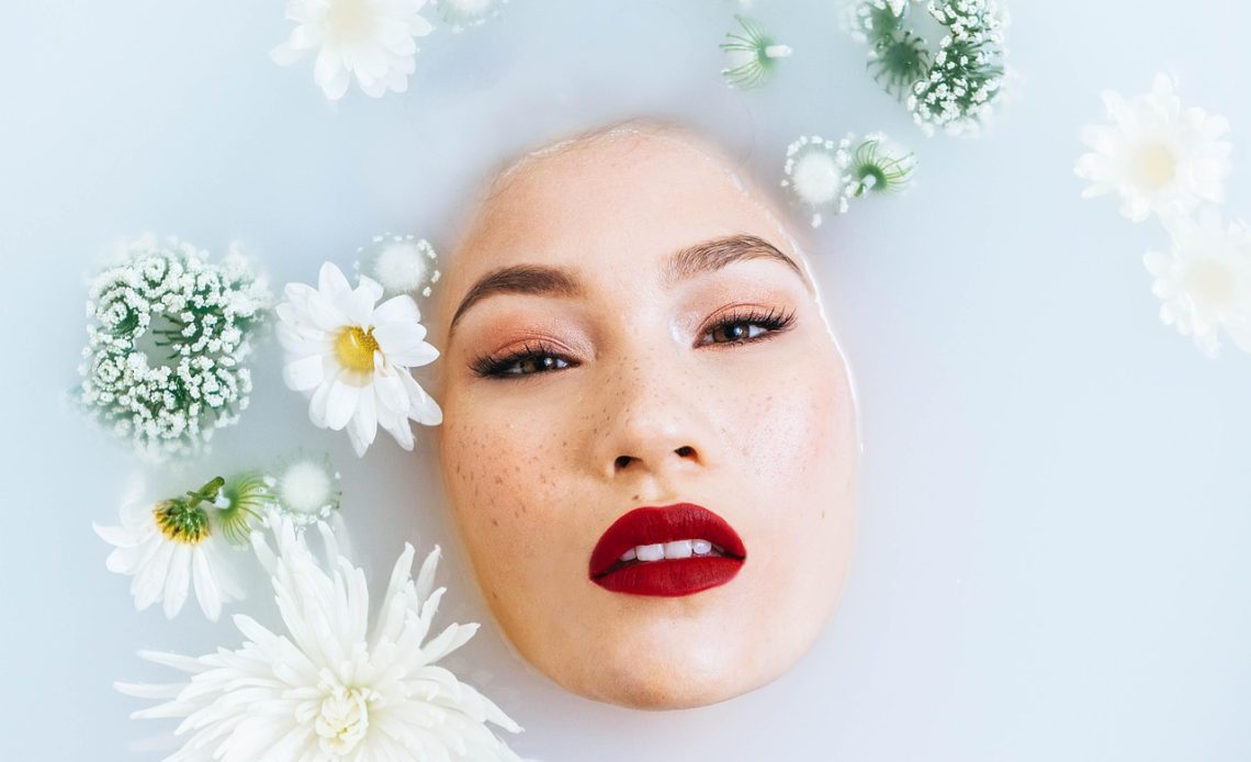 Vrouw bekijkt haar huid in de spiegel tijdens haar ochtendroutine