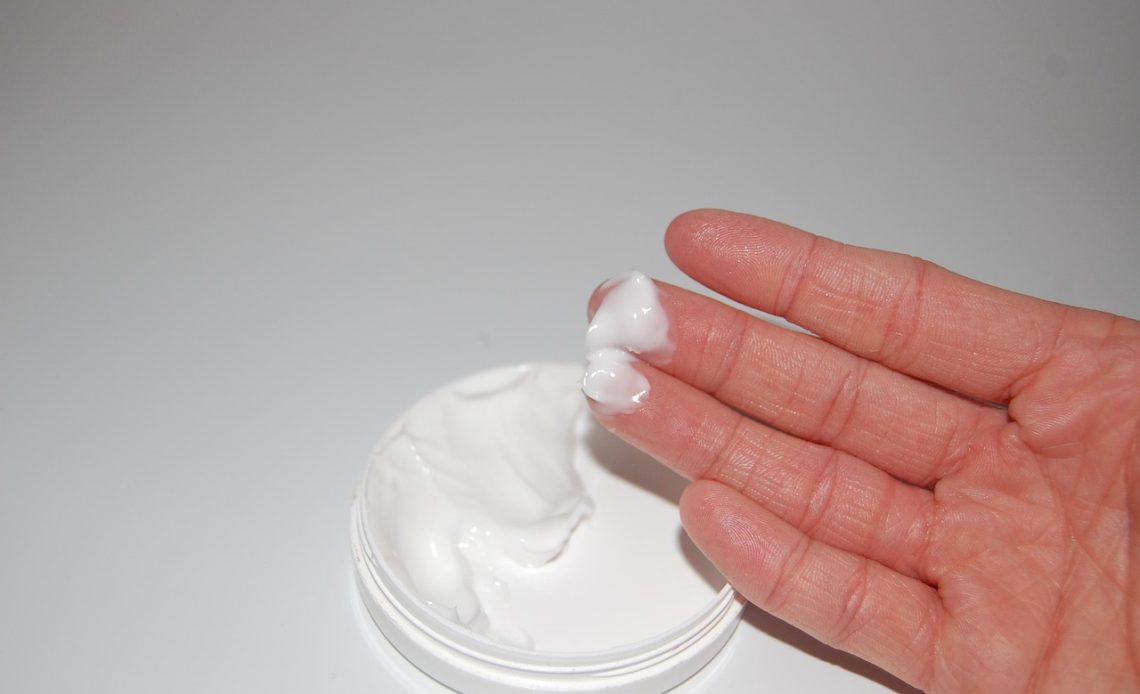 Vrouw die handcrème aanbrengt als onderdeel van haar handroutine