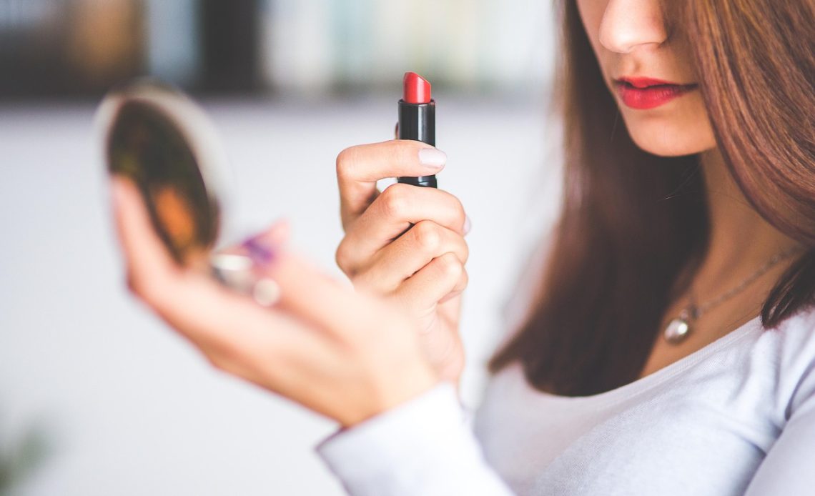 Vrouw die avondmake-up aanbrengt voor een spiegel
