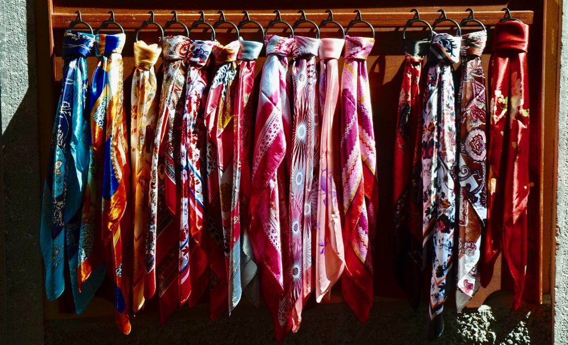 Een zijden neckscarf elegant gestijld om de nek, gecombineerd met een blazer voor een professionele look